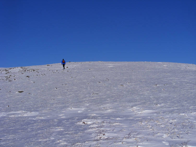 A lone wanderer climbs up towards the summit of Wasdale Red Pike across a